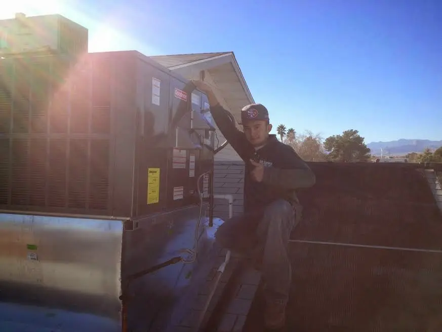 HVAC technician performing HVAC Inspection on a rooftop unit in Oshtemo